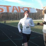 Senior Ross Apter is the first to cross the finish line with the mascot “Rammy” cheering him on.