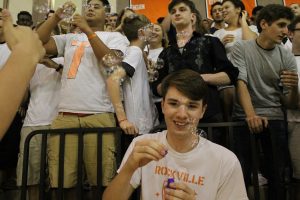 Senior Inferno leader, James Morey blows bubbles by the senior section of the pep rally. 