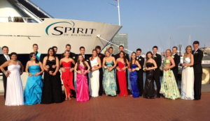 Students gather in gowns and tuxedos to pose for pictures in front of the Spirit of Baltimore on prom night.
