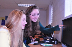 Assistant editor junior Lydia Barr and Student Life editor junior Kaitlynn Shorb work together during their yearbook class. They and the rest of the yearbook staff are looking to keep up their award-winning work this year.