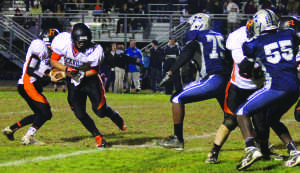 Junior quarterback Chuck Reese hands the ball off to senior runningback Cristian Maldonado in the team's 64-41 win over Magruder HS Oct. 25. The team overcame a 24 point deficit and impressed fans at Magruder's home field.  --Courtesy of Lida Bartsch