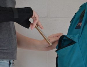 A student pulls a phone out of another student's backpack as a posed example of the alleged thefts of multiple electronics. Some devices are yet to be found and returned. A student pulls a phone out of another student's backpack as a posed example of the alleged thefts of multiple electronics. Some devices are yet to be found and returned. --Mercy Fosah