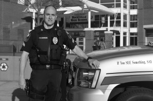 Corporal police officer Rick Halverson stands next to his SUV outside the building. --Adam Bensimhon