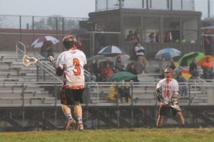 Senior Will Smith cradles the ball while looking to pass the ball to senior Lucas Flavell during the Rams senior night win against Springbrook HS. Smith and Flavell, along with senior Sean Jordan, make up RHSa�� dominant starting offense. --Josh Proctor