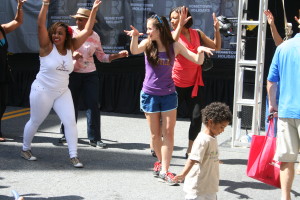 Junior Erin Johnson dances with a Latino dance crew in the middle of Rockville Town Square at Hometown Holidays. She participated in a line dance. --Sarah Wagner