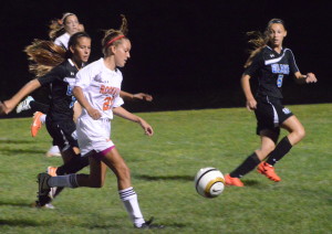 Sophomore Danielle Dean dribbles past two opposing defenders. She scored the second goal in the Lady Rams 3-2 win over Blake HS. --Elissa Britt
