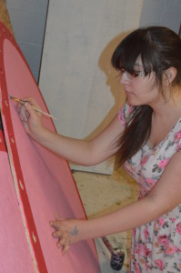 Senior Kelly Flynn paints set pieces for the spring musical, 