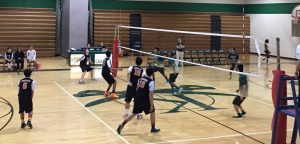 Sophomore outside hitter Doug Aubertin begins his approach as he is getting ready to hit sophomore setter Brandon Kim's high set, while Kennedy players begin to jump to try and block Aubertin's hit.