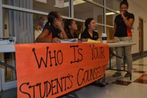 Student ambassadors assist parents in front of the counseling office.