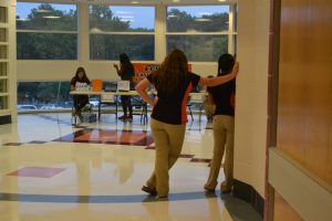 Junior Mary Margaret Bilodeau leans against a wall as ambassadors await the arrival of parents.