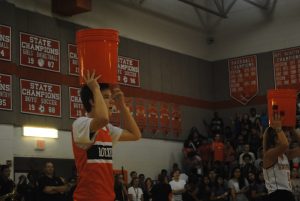 Senior Brendan Gage takes part in the bucket challenge, where his teammate attempts to toss a tennis ball into the bucket  on his head. 