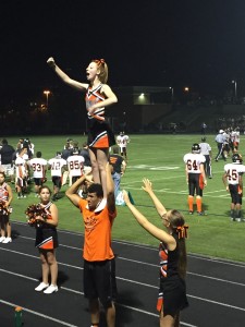 Senior cheerleaders Brendan Andrews and Mackailee Culotta perform a stunt for the fans and cheering to support the football players.