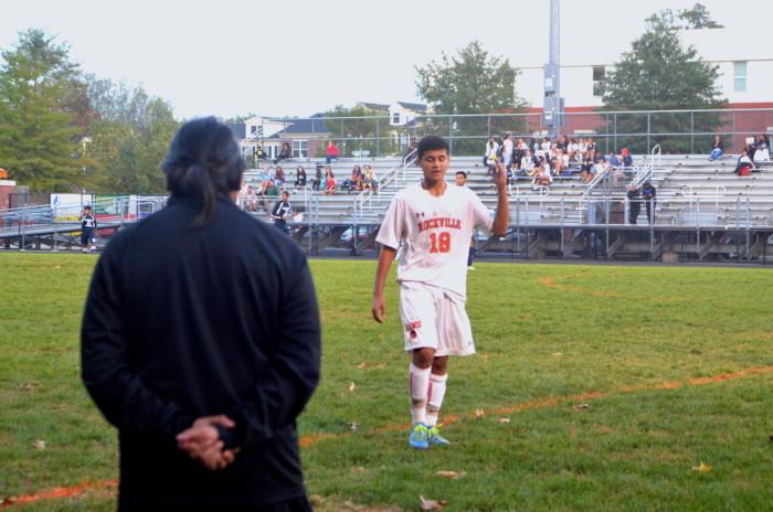 Junior Luis Aquino approaches his coach during the game.