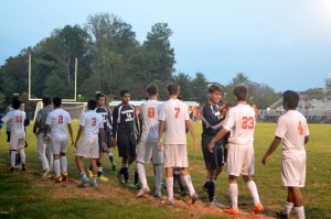 Rockville and Magruder student players line up and high five their opponents at the end of the game.